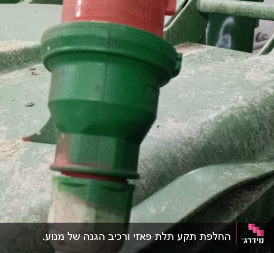 תקע חשמלי תעשייתי ירוק ואדום מוחזק ביד
